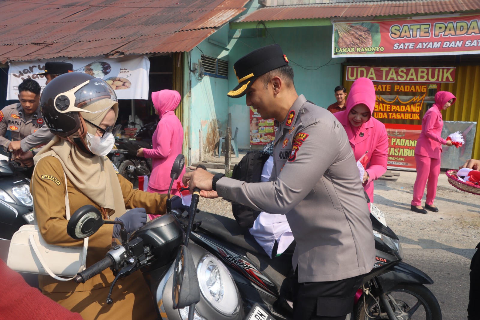 Kapolres Sintang dan Bhayangkari Bagikan Bendera Merah Putih