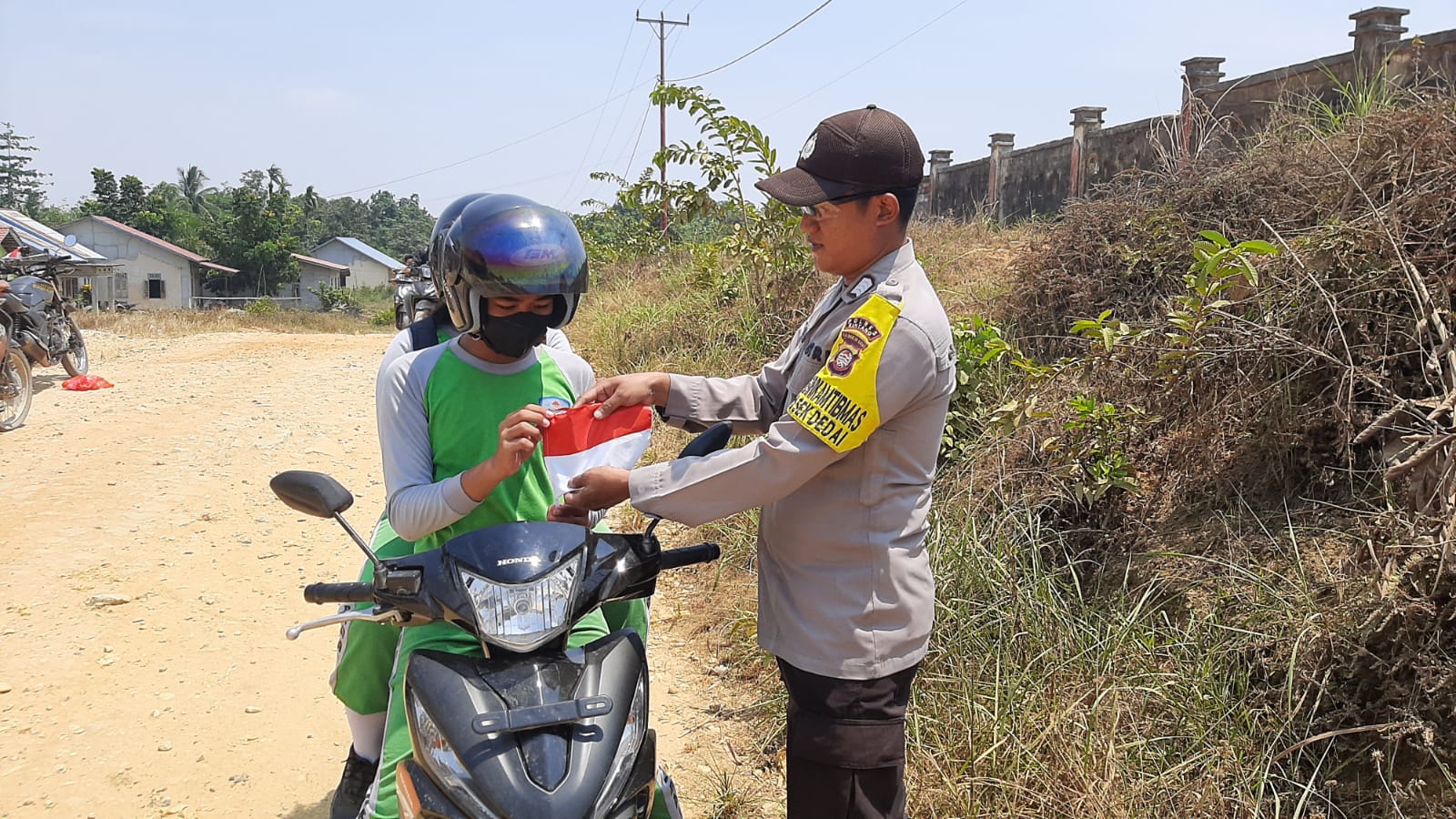Meriahkan HUT RI ke 81,Personil Polsek Dedai Bagikan Bendera Merah Putih ke Pengguna Jalan